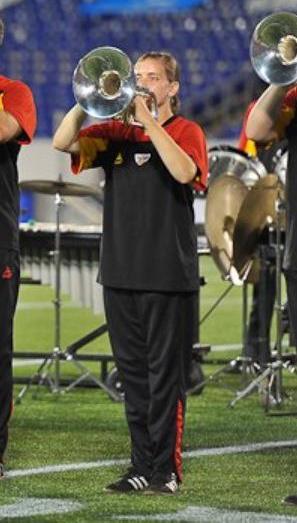 Angela Zoss playing a mellophone and wearing the Star United uniform, a soccer-style jersey and track pants.